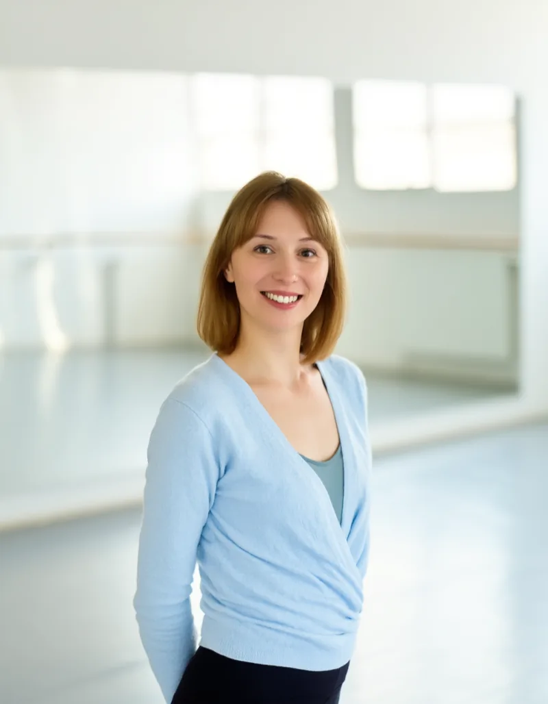 Lena Brandt, studio lead, standing in the sunlit studio in front of the mirror wall