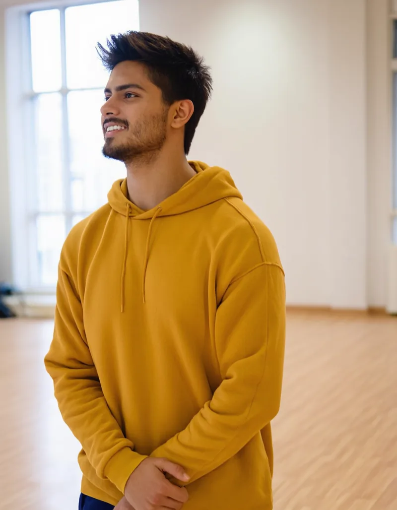 Marek Sobota, hip-hop teacher, standing in the bright studio in a mustard hoodie